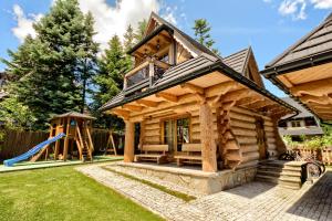une cabane en rondins avec un toboggan et une aire de jeux dans l'établissement Przytulny Domek I, à Zakopane