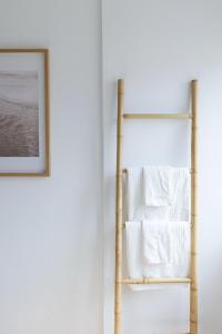 a bamboo towel rack next to a wall with a picture at Golden Nest - Faro Old Town in Faro