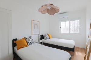 a room with two beds and a ceiling fan at Golden Nest - Faro Old Town in Faro