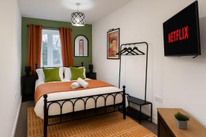 a bedroom with a bed and a tv on the wall at Modern 2BR Aprt Sleeps 6 Parking ,Pet Welcome in Timperley