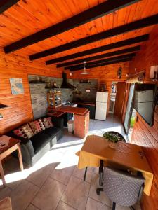 a kitchen and living room with a couch and a table at Confortable cabaña con parrilla in Chascomús