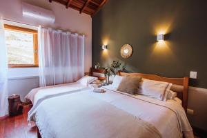 a bedroom with two beds and a window at Smart Hotel Reserva Campos do Jordão in Campos do Jordão