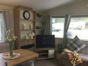 a living room with a tv and a table at 38 The Green in Porthmadog
