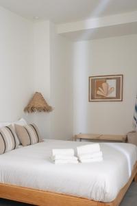 a bedroom with a white bed with towels on it at Outsite Sagres in Sagres