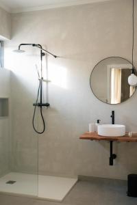 a bathroom with a shower with a sink and a mirror at Outsite Sagres in Sagres