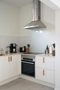 a kitchen with white cabinets and a stove top oven at Outsite Sagres in Sagres