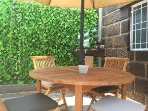 a wooden table with two chairs and an umbrella at Suites colibri in San Miguel de Allende