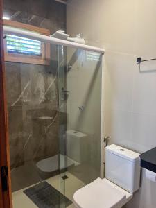 a bathroom with a toilet and a glass shower at Pousada Sitio Preguicas in Barreirinhas +69 photos