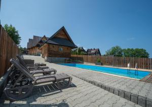 a row of lounge chairs next to a swimming pool at Tośka2 Murzasichle in Murzasichle