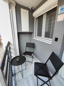 a balcony with two chairs and a table and a window at Vt Homes in Corfu