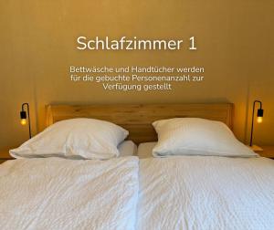 a bed with two pillows and a sign on the wall at Zechenstube in Elbingerode