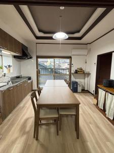 a kitchen with a wooden table in a room at MATAHARI Guest house in Miyazaki