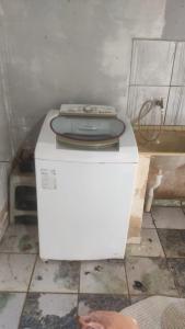 ein Badezimmer mit einer Toilette über einer Waschmaschine in der Unterkunft Santa Maria de Nazaré in Anápolis