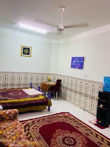 a bedroom with a bed and a table and a couch at Heritage House in Nizwa