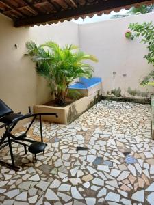 a patio with a chair and a potted plant at Capri Motel in Crato