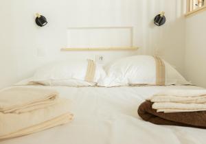 a white bed with white sheets and towels on it at Hyper centre, résové, lave linge, wifi, coin nuit séparé in Dax +4 photos