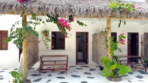 a house with two benches and a thatched roof at Che Brazil Pousada in Cruz