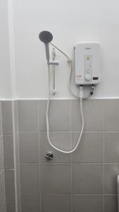 a shower in a bathroom with a white hose at Stay Put by Liza in Jasin