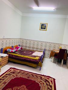 a bedroom with a bed and a table and a rug at Heritage House in Nizwa +10 photos