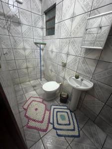 ein Badezimmer mit einem Waschbecken, einem WC und Teppichen in der Unterkunft Santa Maria de Nazaré in Anápolis + 22 Fotos