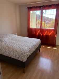 a bedroom with a bed in front of a window at Villa Airelle in La Turbie