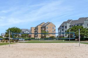Una red de voleibol en una playa frente a las casas. en Pearl Of The Sound, en Manteo