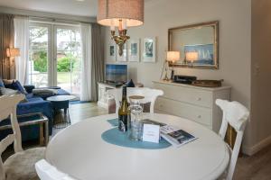 a living room with a table with a bottle of wine at Feriendomizil App 5 in Wenningstedt