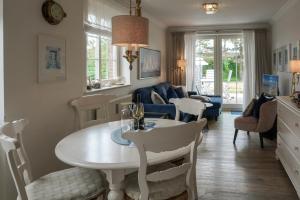 a kitchen and living room with a table and chairs at Feriendomizil App 5 in Wenningstedt