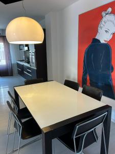 une salle à manger avec une table et un tableau dans l'établissement Casa di Eva, à Reggio de Calabre