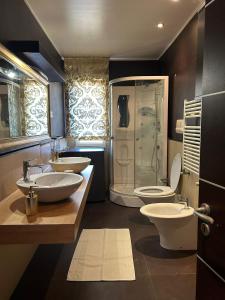 une salle de bain avec deux lavabos et une douche et deux toilettes dans l'établissement Casa di Eva, à Reggio de Calabre