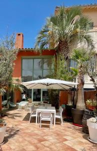 a table and chairs with an umbrella in front of a building at Villa Évasion in Collioure