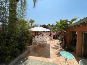 a patio with a table and chairs and trees at Villa Évasion in Collioure