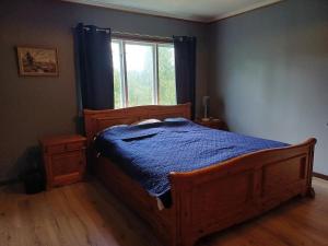 a bedroom with a wooden bed and a window at Filipstad, Lake House Fishing, Nature, Beach in Filipstad