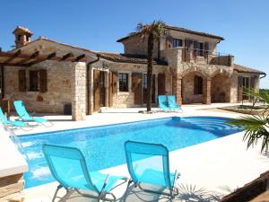 a villa with a swimming pool and blue chairs at Villa Ema in Radetići