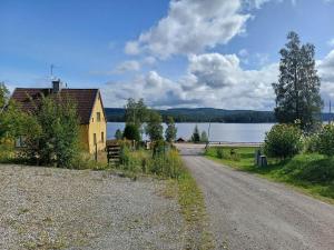 a dirt road next to a house and a lake at Filipstad, Lake House Fishing, Nature, Beach in Filipstad