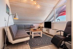 a living room with a couch and a tv at Landhaus Bodensee in Deggenhausertal