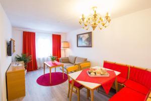 ein Wohnzimmer mit einem roten Sofa und einem Tisch in der Unterkunft FeWo Nebenan in Bad Windsheim