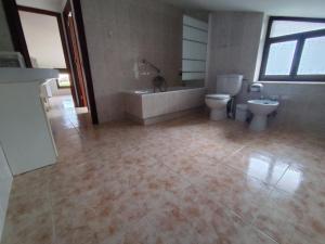 a bathroom with two toilets and a tub and a sink at La Casa de Tito y Cosi in Noja