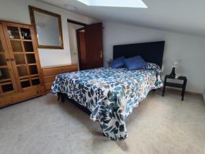 a bedroom with a bed with a blue and white blanket at La Casa de Tito y Cosi in Noja