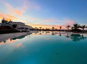 a large swimming pool with a sunset in the background at La Casica del Abuelo Valentín in Torreblascopedro +46 photos