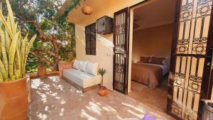 a bedroom with a bed and a couch in a room at Maison Zina in Al Ghar