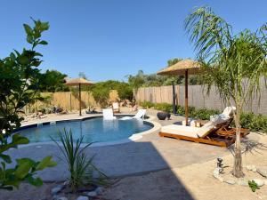 a pool with chairs and umbrellas in a yard at La casa di pantelis with Luxury Pool in Archangelos +46 photos
