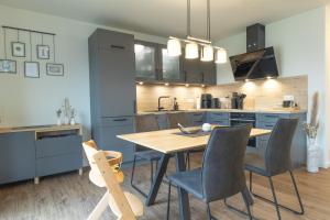 eine Küche und ein Esszimmer mit Tisch und Stühlen in der Unterkunft Ankerherz - besonders familienfreundlich, Hunde willkommen! in Kellenhusen