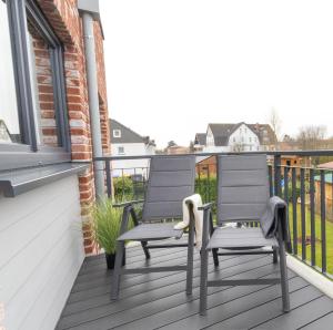 2 Stühle auf einem Balkon in der Unterkunft Ankerherz - besonders familienfreundlich, Hunde willkommen! in Kellenhusen + 23 Fotos