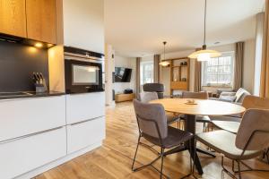 a kitchen and living room with a table and chairs at Villa BalticBliss auf Rügen - direkt am Golplatz mit Sauna und Jacuzzi in Lohme