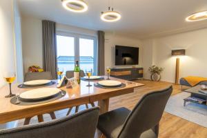 ein Esszimmer mit Tisch und Stühlen und ein Wohnzimmer in der Unterkunft Herz von Kellenhusen 17 Dachterrasse, Sauna, besonders familienfreundlich in Kellenhusen + 20 Fotos