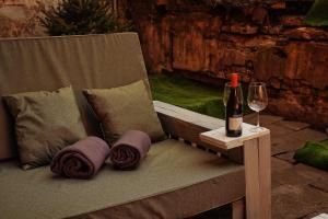 eine Flasche Wein sitzt auf einer Bank mit einem Glas in der Unterkunft Old Town Hideaway in Vilnius + 20 Fotos