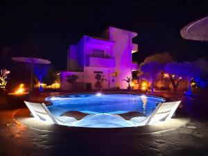 a swimming pool in front of a house at night at La casa di pantelis with Luxury Pool in Archangelos