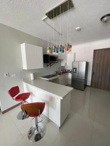 a kitchen with two red chairs and a counter at Joy Luxury Estate Kingston in Kingston