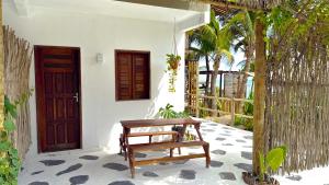 a wooden bench sitting in front of a house at Che Brazil Pousada in Cruz